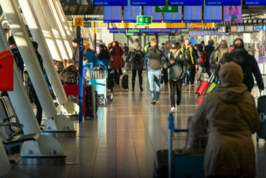 two women with luggage walking through Schiphol airport