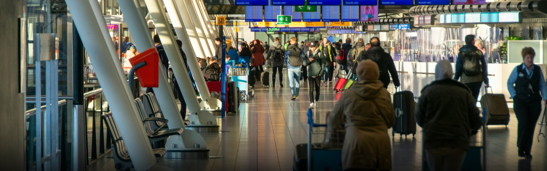 two women with luggage walking through Schiphol airport