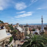 View over Barcelona from Park Güell, with Gaudí architecture in the foreground and the Mediterranean in the distance