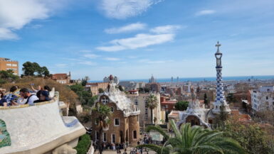 View over Barcelona from Park Güell, with Gaudí architecture in the foreground and the Mediterranean in the distance
