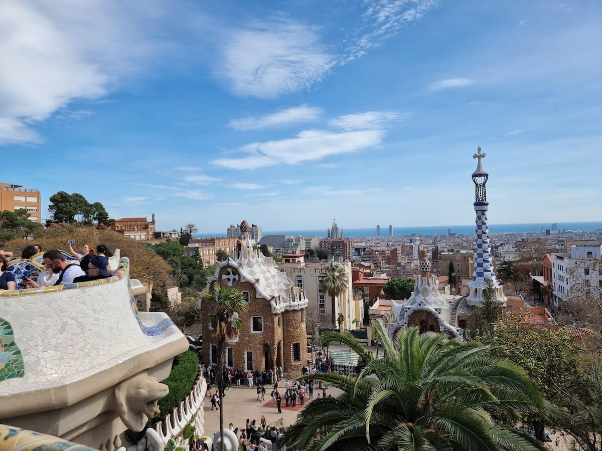 View over Barcelona from Park Güell, with Gaudí architecture in the foreground and the Mediterranean in the distance